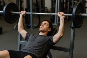 homme en séance de sport pratiquant le développé couché
